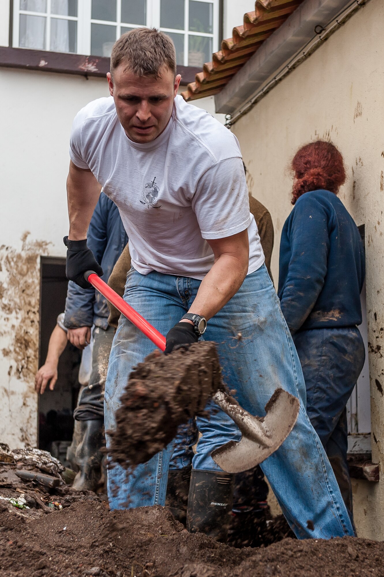 Tech. Sgt. Dustin Guiducci, 65th Operation Support Squadron Air Traffic Controller shovels mud from a house that was damaged by recent flooding. Airmen from the 65th Operations Support Squadron and other units from Lajes Field volunteered to remove water and mud from homes and businesses following severe rain and flooding in Porto Judeu, Azores, Mar. 15, 2013. Roughly 30 homes were damaged from the flooding.  (Photo by Lucas Silva)
