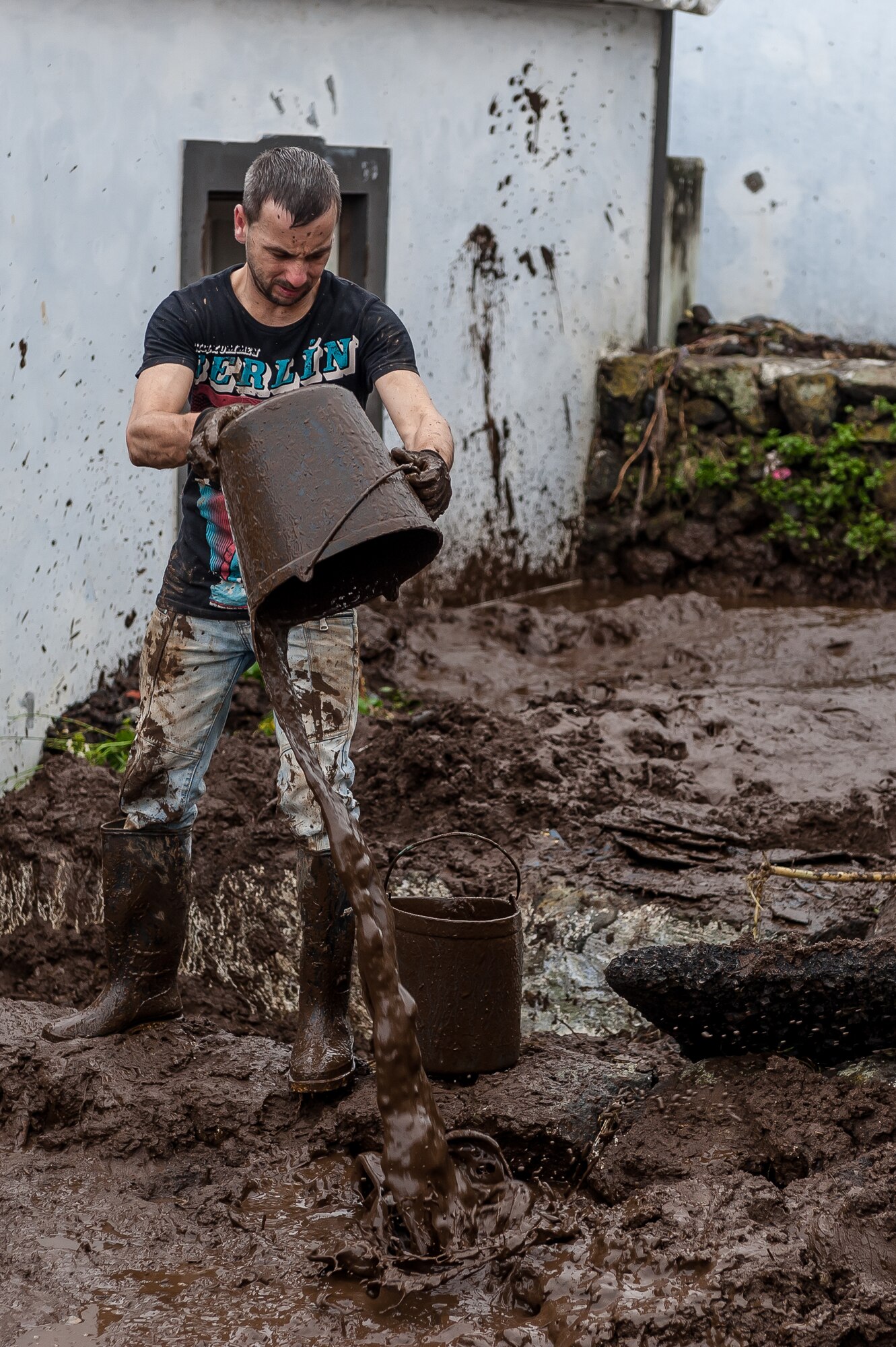 Nelson Silveira lends a hand to remove mud from his neighbor’s home. Airmen from the 65th Operations Support Squadron and other units from Lajes Field volunteered to remove water and mud from homes and businesses following severe rain and flooding in Porto Judeu, Azores, Mar. 15, 2013. Roughly 30 homes were damaged from the flooding.  (Photo by Lucas Silva)
