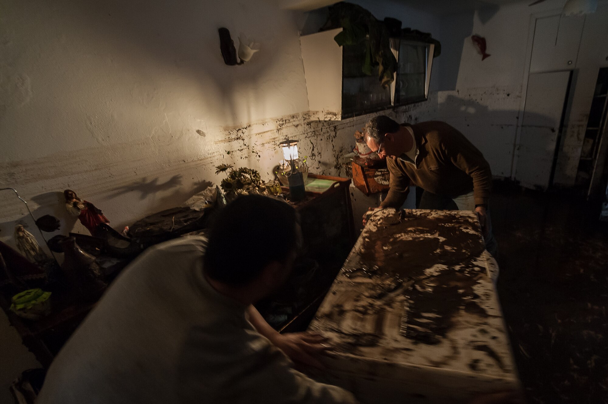 (r-l) Fernando Silva and his brother Sandro Silva move a deep freezer to a safe location so they can salvage some of the food from it after their home was submerged in water and mud from recent flooding. Airmen from the 65th Operations Support Squadron and other units from Lajes Field volunteered to remove water and mud from homes and businesses following severe rain and flooding in Porto Judeu, Azores, Mar. 15, 2013. Roughly 30 homes were damaged from the flooding.  (Photos by Lucas Silva)
