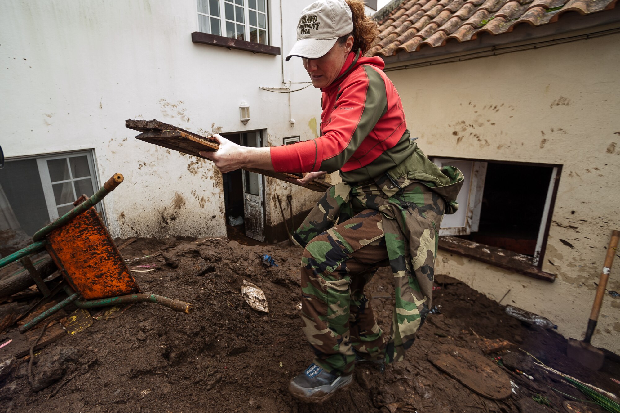 Stacey Guiducci wife of Tech. Sgt.Dustin Guiducci, 65th Operation Support Squadron Air Traffic Controller removes piles of wood from a house that was damaged by recent flooding in Porto Judeu. Airmen from the 65th Operations Support Squadron and other units from Lajes Field volunteered to remove water and mud from homes and businesses following severe rain and flooding in Porto Judeu, Azores, Mar. 15, 2013.  Roughly 30 homes were damaged from the flooding.  (Photo by Lucas Silva)
