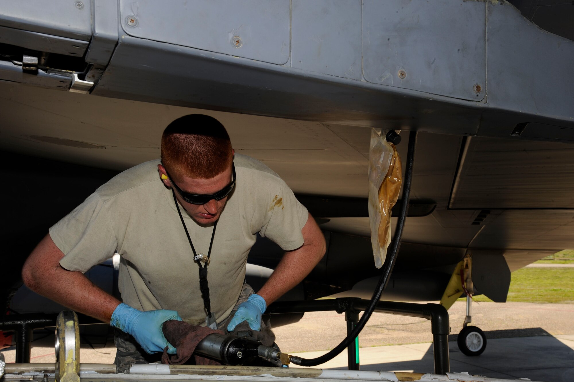 Airman 1st Class Thomas Krezel, 2nd Maintenance Squadron Weapons Standardization, uses a grease gun to remove pins from the pylon of a B-52H Stratofortress during a training exercise on Barksdale Air Force Base, La., March 15. The exercise reinforced munitions Airmen's skills in loading and unloading munitions quickly and effectively in a combat situation. (U.S. Air Force photo/Airman 1st Class Andrew Moua)