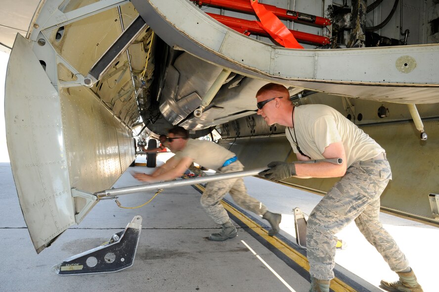 Airman 1st Class Thomas Krezel, left, and Staff Sgt. Christopher Ueckler, both from the 2nd Maintenance Group Weapons Standardization, lift the bomb bay door of a B-52H Stratofortress on Barksdale Air Force Base, La., March 15. The Airmen were down-loading ordnance as part of a recent exercise. (U.S. Air Force photo/Airman 1st Class Andrew Moua)