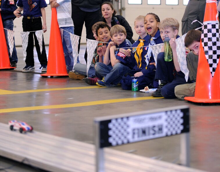 Cub Scouts and family members cheer on the racing cars March 16, 2013, during the Cub Scout Pinewood Derby event held in the 100th Civil Engineering Squadron Fire Department at RAF Mildenhall, England. The event featured more than 50 Cub Scouts from five packs located in the UK. The first Pinewood Derby event was started by Don Murphy, cub master for Pack 280C in 1952. The event was created as a father-son event that mimicked the Soap Box Derby. (U.S. Air Force photo by Tech. Sgt. Stacia Zachary/Released)
