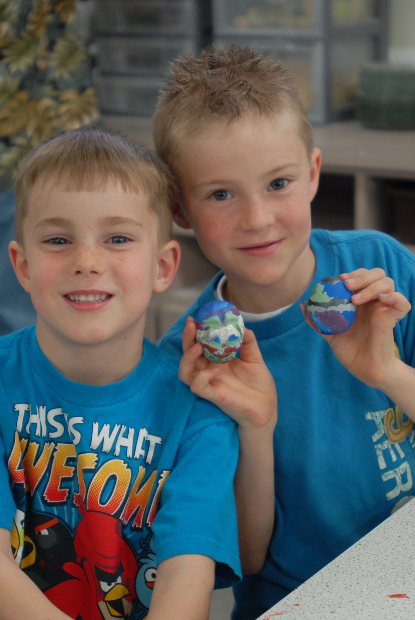 GOODFELLOW AIR FORCE BASE, Texas – Jakob Lord and Zachary Lord hold up their painted eggs March 15 at the Arts and Craft center here. The Arts and Crafts center offers the introduction of pottery as well as ceramic painting classes. (U.S. Air Force photo/ Airman 1st Class Breonna Fields)