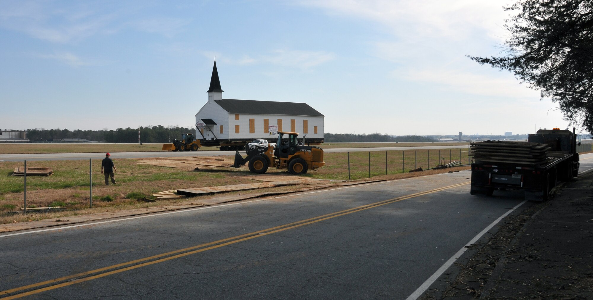 Personnel from Hercules House Movers work to create a path through the mud underneath the Dobbins Air Reserve Base chapel on March 17, to finish the relocation to the Army National Guard side of the base. The Dobbins chapel taxied across the Dobbins ARB, Ga., runway to the Army National Guard side of the base following a ceremony honoring its service to the nation’s military members. (U.S. Air Force photo/Senior Airman Elizabeth Van Patten)