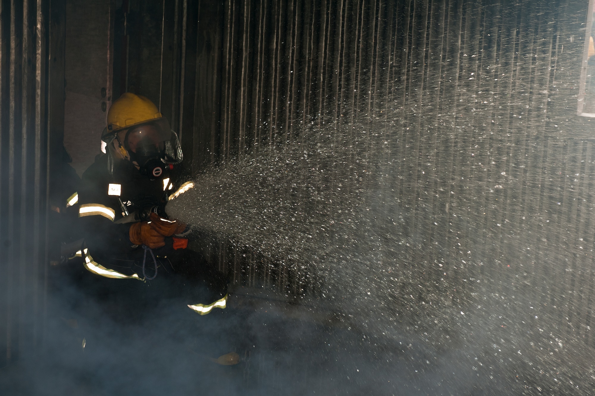 A firefighter with the Republic of Korea air force 38th Fighter Group sprays water at a fire during a training scenario at Kunsan Air Base, Republic of Korea, Mar. 18, 2013. The scenario was part of exercise Beverly Midnight 13-2, which is designed to assess the abilities of US and ROK air force firefighters. (U.S. Air Force photo by Staff Sgt. Jonathan Fowler/Released)