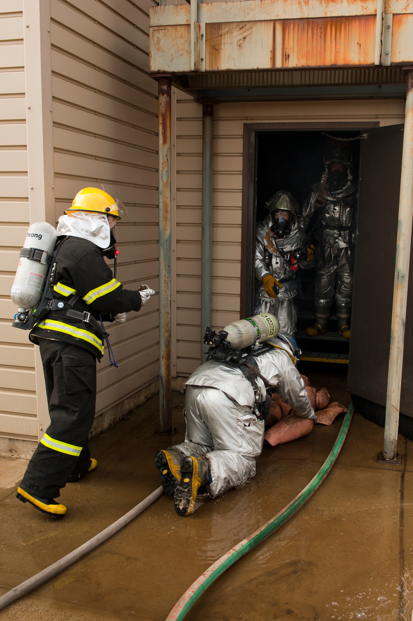 Firefighters with the 8th Civil Engineer Squadron and the Republic of Korea air force 38th Fighter Group remove a simulated burn victim dummy, from a building during exercise Beverly Midnight 13-2 at Kunsan Air Base, Republic of Korea, Mar. 18, 2013. The scenario was designed to test the ability of the firefighters to work together and showcase their capabilities. (U.S. Air Force photo by Staff Sgt. Jonathan Fowler/Released)