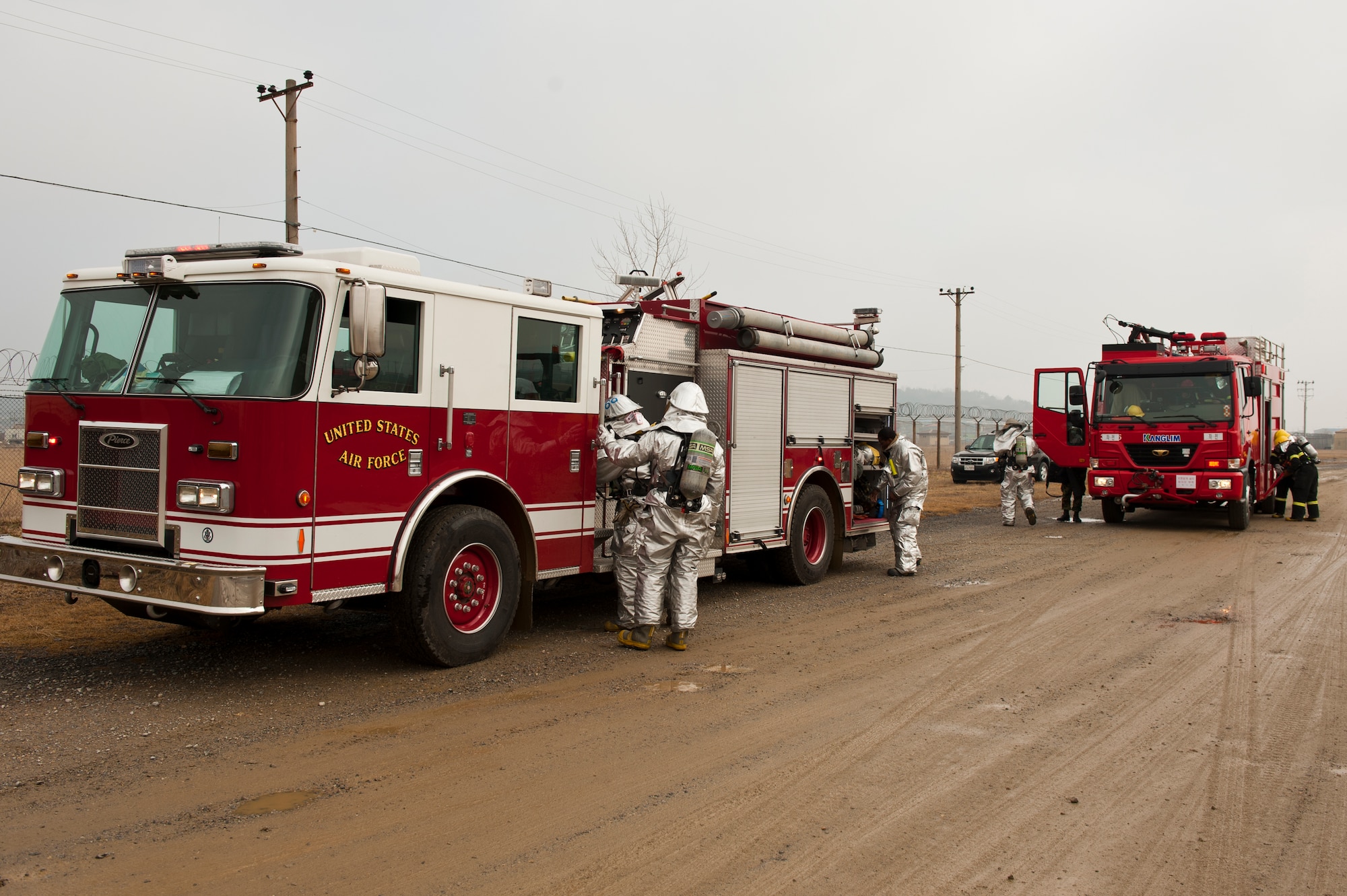 Firefighters with the 8th Civil Engineer Squadron and the Republic of Korea air force 38th Fighter Group prepare their equipment while responding to a fire at Kunsan Air Base, Republic of Korea, Mar. 18, 2013. This was part of exercise Beverly Midnight 13-2 and was designed to test US and ROK air forces’ ability to respond to various scenarios. (U.S. Air Force photo by Staff Sgt. Jonathan Fowler/Released)