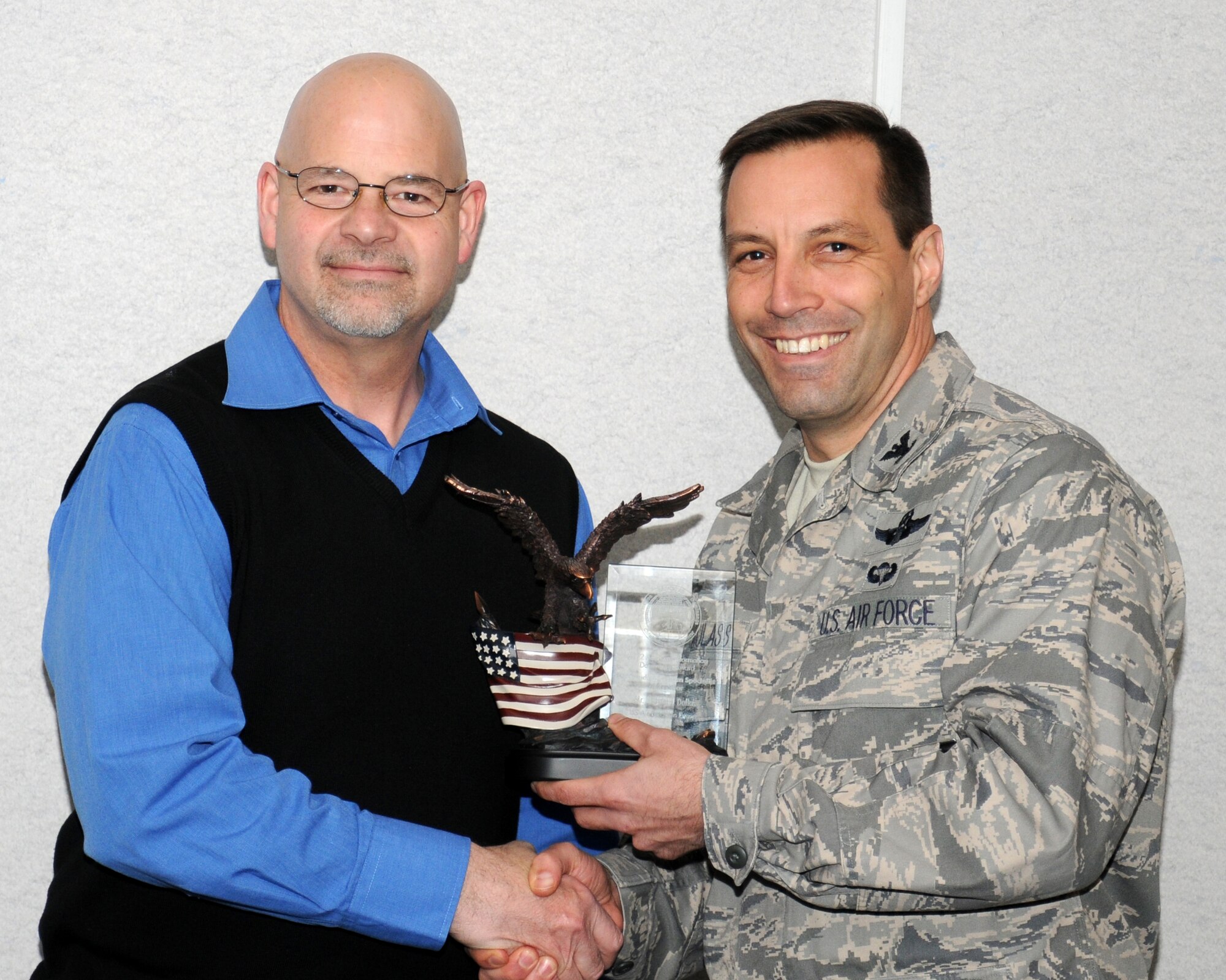 Right, Col. Christopher Kulas, 100th Air Refueling Wing commander presents the 2012 Air Force Information Dominance Civilian Specialist of the Year award to Michael Dallas, 100th Communication Squadron deputy director of cyber operations from Alpena, Mich., March 15, 2013, at RAF Mildenhall, England. Dallas also won the 2012 100th CS Category I Civilian of the Year. (U.S. Air Force photo by Gina Randall/Released)