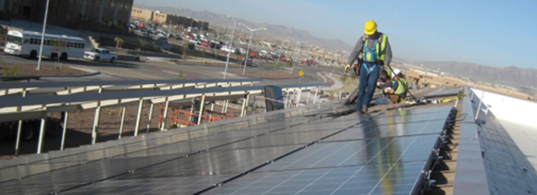 A contractor surveys his work atop a dining facility on Fort Bliss, Texas. Huntsville Center manages multiple types of projects on U.S. Army installations, like this facility-level solar project that was part of an Energy Savings Performance Contract.