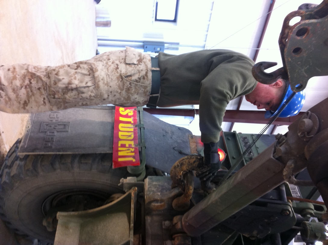 Lance Cpl Jake D. Funk, 1st Battalion 6th Marines practices unstowing and stowing the material handling crane on the AMK36 wrecker at Ft. Leonard Wood, MO while attending Vehicle Recovery Operator Course 3-12.  This is one of the first events students learn in the course prior to becoming certified as a  3536 NMOS (Vehicle Recovery Operator).