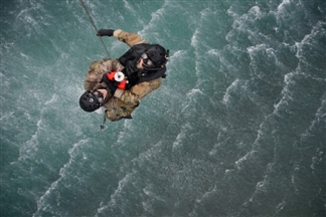 U.S. Air Force Staff Sgt. Nathan Vogel and Senior Airman Zack Asmus are hoisted out of the water during water rescue training off the coast of Torii Station, Japan on Feb. 26, 2013.  The water rescue is part of bilateral training between the U.S. military, Japanese coast guard and emergency services to strengthen communications and processes in the event of an aircraft mishap.  Vogel and Asmus are attached to the 320th Special Tactics Squadron as pararescuemen.  