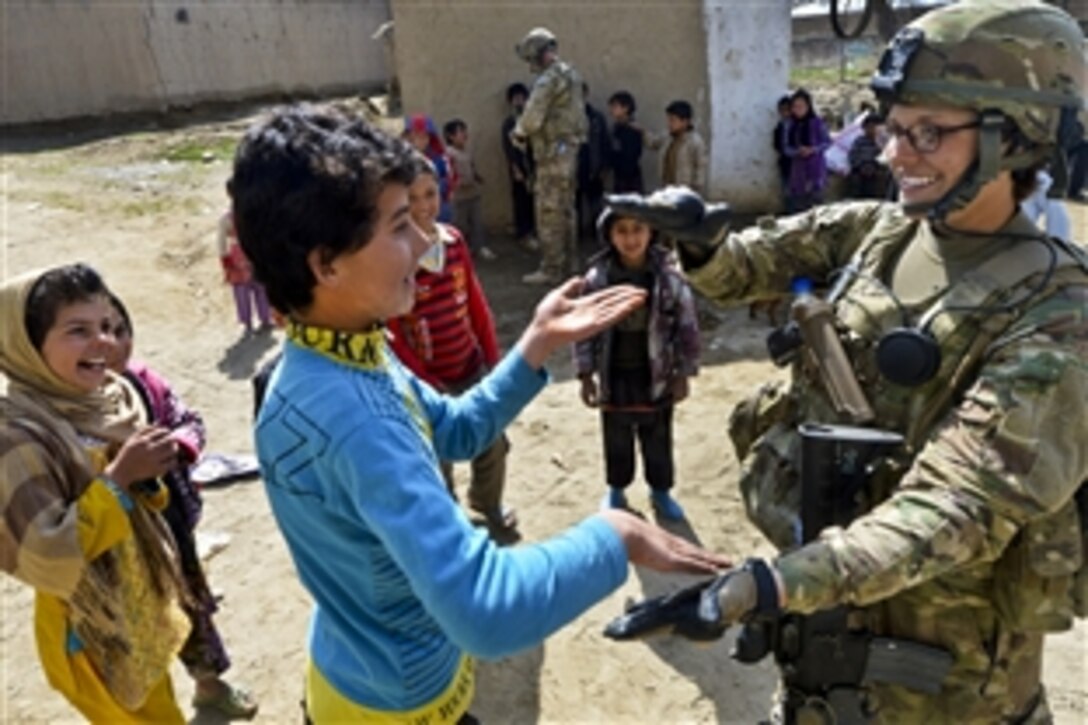 U.S. Air Force Staff Sgt. Elizabeth Rosato meets with Afghan school children outside of Bagram Airfield, Afghanistan, March 11, 2013. The Reaper team conducts patrols near the airfield to counter improvised explosive devices and indirect fire attacks as well as to engage Afghan support in protecting the base. Rosato is assigned to the 755th Expeditionary Security Forces Squadron Reaper Team 1.