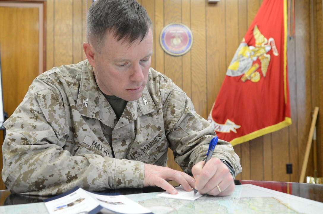 Col. David Maxwell, base commander, Marine Corps Base Quantico, fills out his Navy-Marine Corps Relief Society contribution form after the NMCRS fund drive kick-off meeting at Little Hall on March 18, 2013. This year’s monetary goal is $175,000 and 100 percent contact.