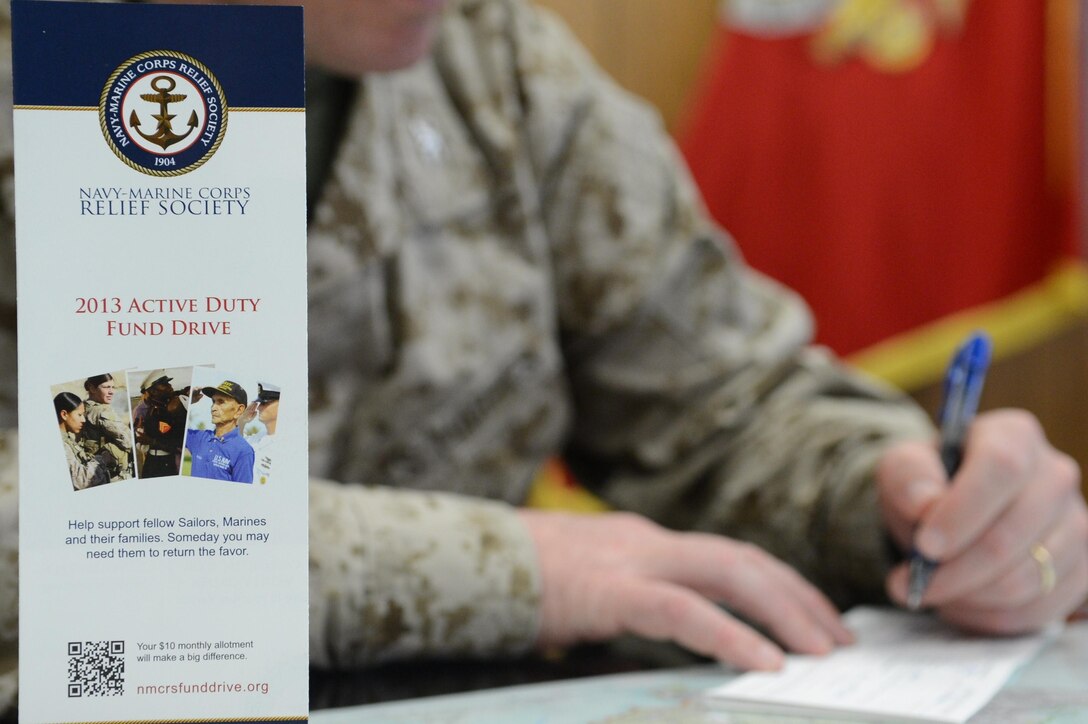 Col. David Maxwell, base commander, Marine Corps Base Quantico, fills out his Navy-Marine Corps Relief Society contribution form after the NMCRS fund drive kick-off meeting at Little Hall on March 18, 2013. This year’s monetary goal is $175,000 and 100 percent contact. 