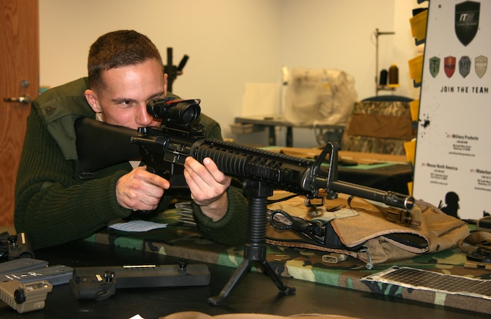 Sgt. Michael Cummins, an Amphibious Assault Vehicle crew chief with Amphibious Assault Platoon at The Basic School, looks through the sight of an M-16 in the human factors lab at Gruntworks. Gruntworks serves as a “workshop” for the Marine Expeditionary Rifle Squad, or MERS, team to test existing and emerging equipment to help MCSC provide improved items to infantry Marines. 