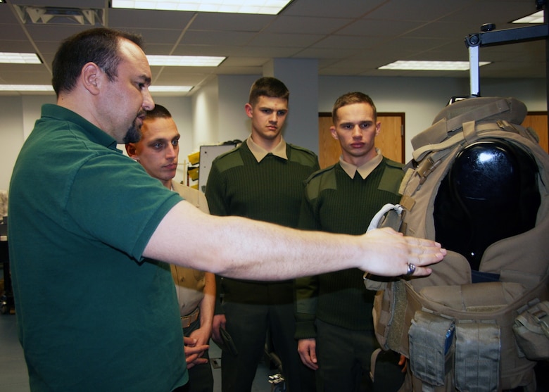 Carl Desantis (left), Gruntworks director, talks to a group of Marines about the improved modular tactical vest. The Marine Expeditionary Rifle Squad, or MERS, team worked with the program manager for Infantry Combat Equipment to develop and field the new fragmentation vest for the Marine Corps.