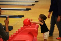 A little girl pushes a bowling ball down a ramp during an event at the Bonnyman Bowling Center aboard Camp Lejeune, N.C., March 16, 2013. Families of Marines with Combat Logistics Battalion 22, Combat Logistics Regiment 27, 2nd Marine Logistics Group enjoyed food, beverages and gift bags filled with snacks provided by the family readiness officer. 