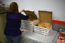 A Marine spouse grabs slices of pizza for her family during an event at Bonnyman Bowling Center aboard Camp Lejeune, N.C., March 16, 2013. Marines and their families with Combat Logistics Battalion 22, Combat Logistics Regiment 27, 2nd Marine Logistics Group shared each other’s company as they built friendships while enjoying pizza, beverages and snacks. 