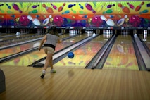 A Marine spouse throws a bowling ball down the lane during an event at the Bonnyman Bowling Center aboard Camp Lejeune, N.C., March 16, 2013. Marines and their families built relationships with each other and enjoyed pizza, beverages and snacks during the event. 