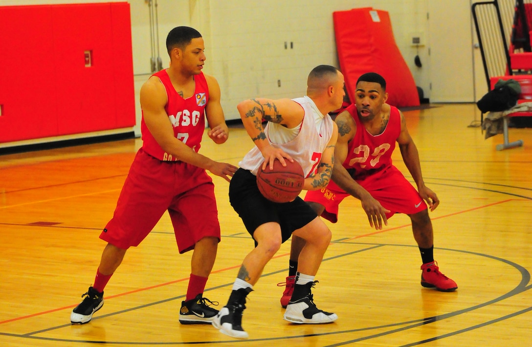 Ajawon Gadison, right, and Charles Jones, left, players for Marine Corps Embassy Security Group’s American League intramural basketball team, play defense against Micheal Martinet, a player for Combat Instructor Weapons team on March 18, 2013, at Barber Physical Activity Center. MCESG defeated CI WPNS, 66-44. (U.S. Marine Corps photo by Cpl. Paris Capers/Released)