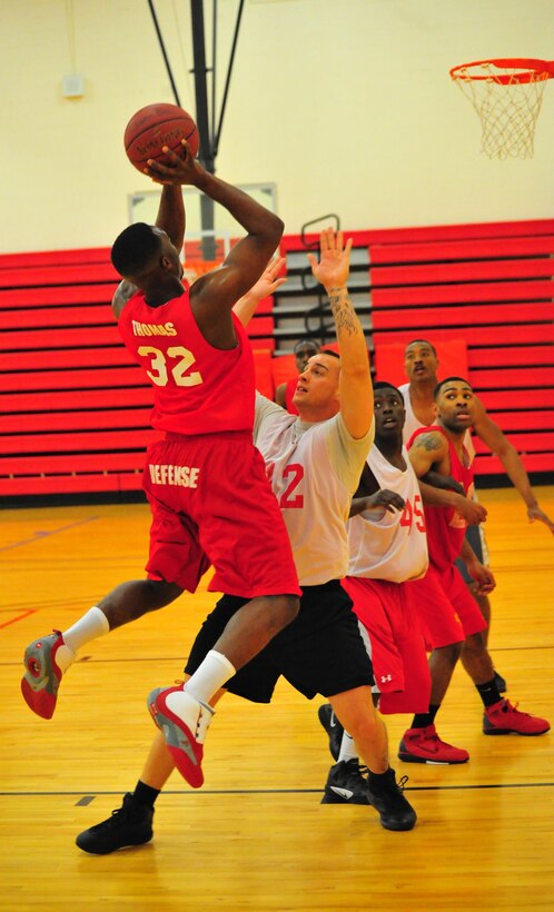 Stephen Sheaton, a player for Combat Instructor Weapons’ American League intramural basketball team, attempts to block the shot of Loren Thomas, a player for Marine Corps Embassy Security Group’s team on March 18, 2013, at Barber Physical Activity Center. MCESG defeated CI WPNS, 66-44.