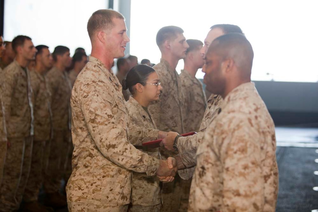 Newly promoted Sgt. Stephen Spencer, wire chief, Joint Task Force Enabler, 15th Marine Expeditionary Unit, shakes hands with Col. Scott D. Campbell, his commanding officer, in the hangar bay of USS Peleliu, March 1. The 15th MEU is deployed as part of the Peleliu Amphibious Ready Group as a U.S. Central Command theater reserve force, providing support for maritime security operations and theater security cooperation efforts in the U.S. 5th Fleet area of responsibility. (U.S. Marine Corps photo by Cpl. Danny L. Shaffer)