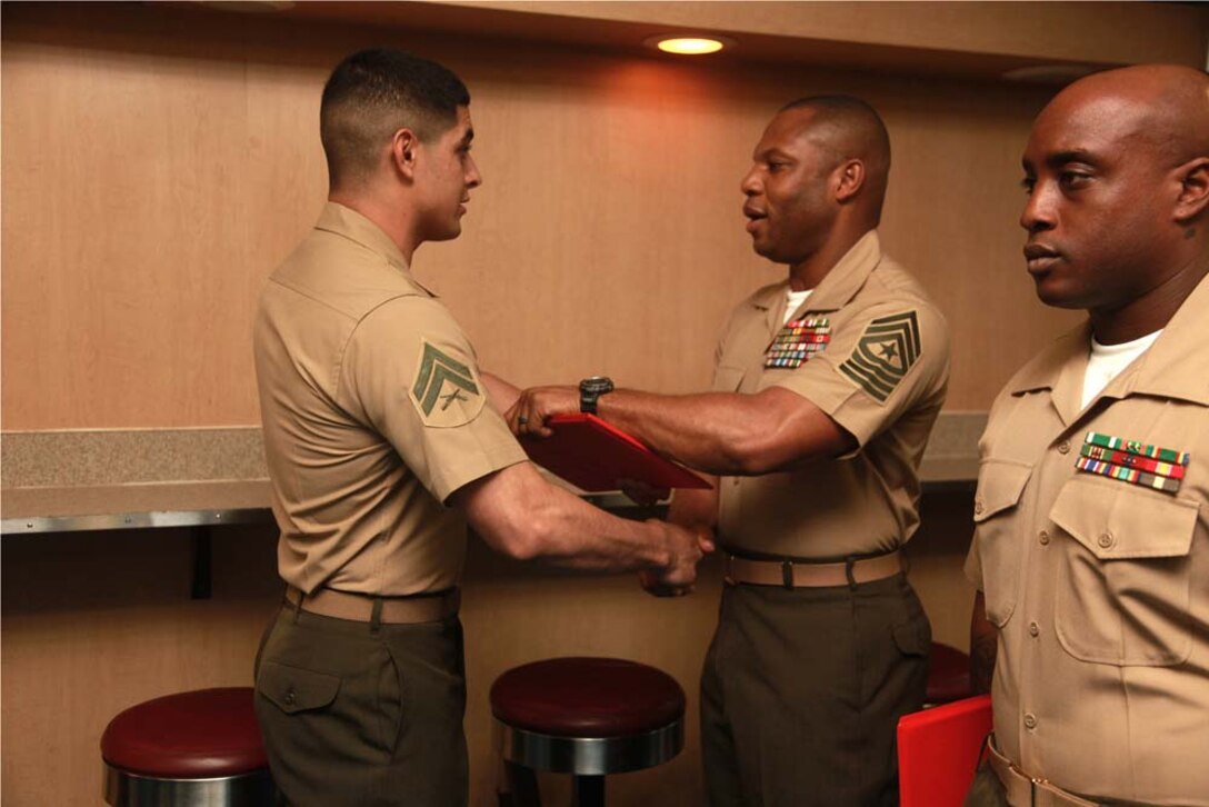 Corporal Juan A. Hernandez, team leader, Security Element, 81mm Mortars/Tactical Recovery of Aircraft and Personnel Platoon, Weapons Company, Battalion Landing Team 3/5, 15th Marine Expeditionary Unit, receives his graduation certificate from Sgt. Maj. John W. Scott, the 15th MEU's sergeant major, on the troop mess decks of USS Peleliu during Corporals' Course graduation, March 15. Corporals' Course is a professional military education for enlisted Marines designed to give corporals the tools to become more effective small unit leaders. The 15th MEU is deployed as part of the Peleliu Amphibious Ready Group as a U.S. Central Command theater reserve force, providing support for maritime security operations and theater security cooperation efforts in the U.S. 5th Fleet area of responsibility. Hernandez, 22, is from Santa Rosa, Calif. (U.S. Marine Corps photo by Cpl. John Robbart III)