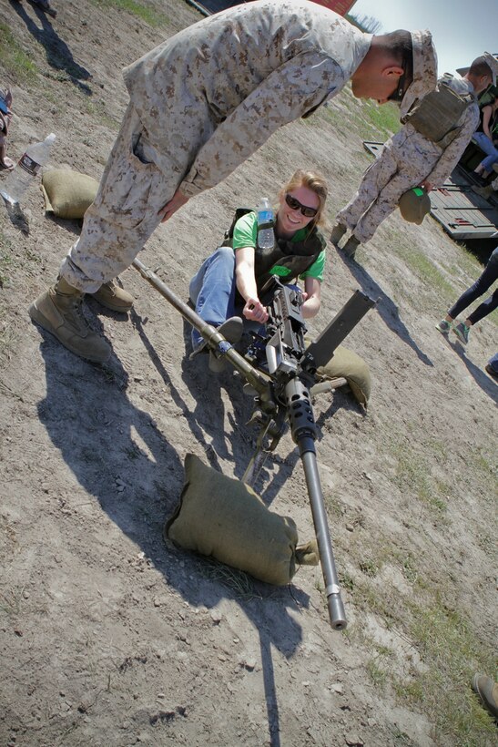 Sarah Phillips, the wife of 2nd Lt. Evan Phillips of Charlie Company, 3rd Assault Amphibian Battalion, pulls back the bolt of an M2 .50 caliber machine gun as Sgt. Jonathan Moebius a native of Indianapolis and a section leader serving with Headquarters and Service Company, 3rd AABn, guides her through the process during the battalion’s Jane Wayne Day here, March 15, 2013. Jane Wayne Day provides spouses and family members of Marines and sailors with the opportunity to get a taste of Marine Corps training and experience a day in the life of a Marine with 3rd AABn. Family members participated in Marine Corps Martial Arts Program training, received instruction on several Marine Corps weapon systems, and rode on amphibious assault vehicles.