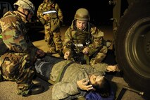 Staff Sgt. Chana Lawlor, left, and Staff Sgt. Tavis Riley, 8th Logistics Readiness Squadron, secure Staff Sgt. Angela Green, 8th Aircraft Maintenance Squadron, to a stretcher during exercise Beverly Midnight 13-2 at Kunsan Air Base, Republic of Korea, Mar. 19, 2013.  The scenario tested the 8th LRS’s ability to respond to and treat injured personnel following a ground attack. (U.S. Air Force photo by Senior Airman Marcus Morris/Released)