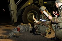 Airman 1st Class Roosevelt Cooper, 8th Logistics Readiness Squadron, checks his Airman’s Manual for how to treat a leg fracture while Airman Steven Schulze, 8th LRS notifies his unit control center of the incident during exercise Beverly Midnight 13-2 at Kunsan Air Base, Republic of Korea, March 19, 2013. The scenario tested the 8th LRS’s ability to respond to and treat injured personnel following a ground attack. (U.S. Air Force photo by Senior Airman Marcus Morris/Released)