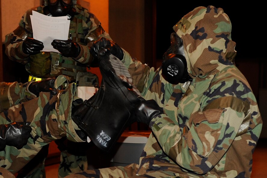 Senior Airman Stephen Shannon, 8th Civil Engineer Squadron, helps Staff Sgt. Hezekiah Barrett, 8th Medical Operations Squadron, remove contaminated Mission Oriented Protective Posture gear during exercise Beverly Midnight 13-2 at Kunsan Air Base, Republic of Korea, March 19, 2013. After finding contamination on his teammate, Shannon  alerted emergency personnel  and helped Barrett remove the gear. (U.S. Air Force photo by Senior Airman Marcus Morris/Released)