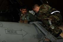 Staff Sgt. Gregory Stethem, right, 8th Aircraft Maintenance Squadron, assists Capt. Ruben Amezaga, 35th Fighter Squadron, during exercise Beverly Midnight 13-2 at Kunsan Air Base, Republic of Korea, March 19, 2013. Beverly Midnight 13-2 was a joint exercise involving US and ROK air forces and evaluated their ability to respond to various scenarios. (U.S. Air Force photo by Senior Marcus Morris/Released)