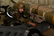 Staff Sgt. Gregory Harrison, 8th Aircraft Maintenance Squadron, secures a bomb to a stand during exercise Beverly Midnight 13-2 at Kunsan Air Base, Republic of Korea, March 19, 2013. The Airmen prepared an F-16 Fighting Falcon for the first set of take-offs for the exercise, which assessed the readiness level of the base. (U.S. Air Force photo by Senior Airman Marcus Morris/Released)