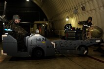 Staff Sgt. Gregory Harrison, right, 8th Aircraft Maintenance Squadron, guides Senior Airman Jade Call, 8th AMXS, to lower a bomb onto a stand during exercise Beverly Midnight 13-2 at Kunsan Air Base, Republic of Korea, March 19, 2013. The Airmen prepared an F-16 Fighting Falcon for the first set of take-offs for the exercise, which assessed the readiness of the base. (U.S. Air Force photo by Senior Airman Marcus Morris/Released)