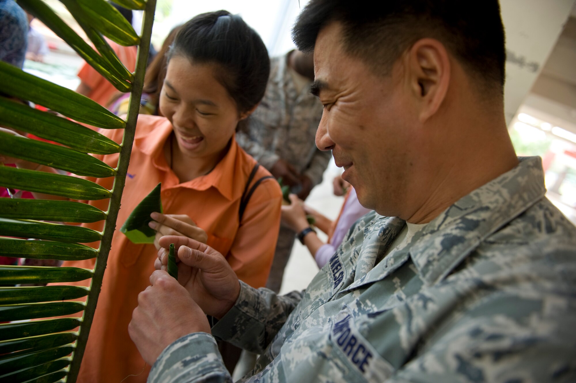 A student shows Master Sgt. Jeff Mikkelson how to create a flower using pandan leaves as Airmen from the U.S. Air Force, Thai Royal Air Force and Republic of SIngapore Air Force visit Korat Pittyakom School during Cope Tiger 13 in Nakhon Ratchasima, Thailand, March 18, 2013. Approximately 50 exercise pariticipants visited the school during a cultural exchange visit. More than 300 U.S. service members are participating in CT13, which offers an unparalleled opportunity to conduct a wide spectrum of large force employment air operations and strengthen military-to-military ties with two key partner nations, Thailand and Singapore. (U.S. Air Force photo/2nd Lt. Jake Bailey)