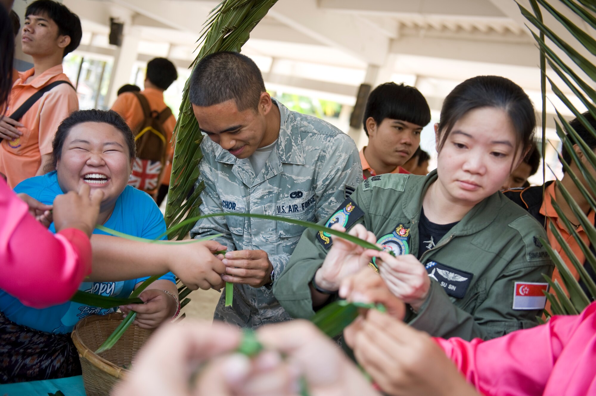 Thai students show Airmen from the U.S. Air Force, Thai Royal Air Force and Republic of SIngapore Air Force how to make flowers using pandan leaves during a visit Korat Pittyakom School during Cope Tiger 13 in Nakhon Ratchasima, Thailand, March 18, 2013. Approximately 50 exercise pariticipants visited the school during a cultural exchange visit. More than 300 U.S. service members are participating in CT13, which offers an unparalleled opportunity to conduct a wide spectrum of large force employment air operations and strengthen military-to-military ties with two key partner nations, Thailand and Singapore. (U.S. Air Force photo/2nd Lt. Jake Bailey)