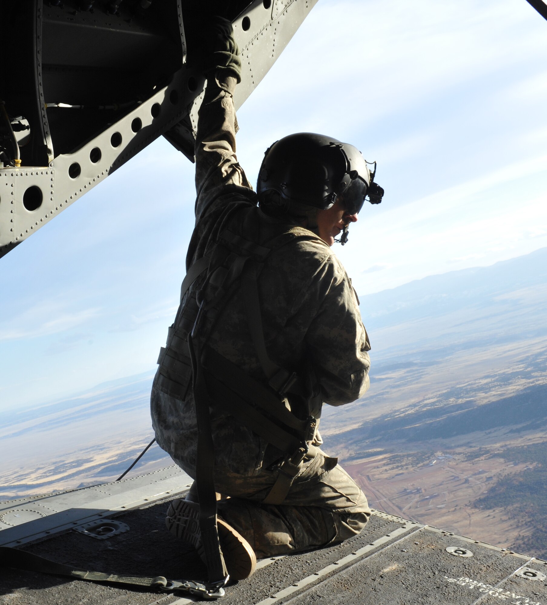 Staff Sgt. Edwin Thompson, Colorado Army National Guard Aviation Support Facility crew chief, watches 10th Special Forces Group members parachute as part of a training mission March 6, 2013, at Fort Carson, Colo.  With the assistance of the Aviation Support Facility members and assets, 10th SFG members parachuted from the Chinook as part of a training mission. (U.S. Air Force photo by Airman 1st Class Riley Johnson/Released)