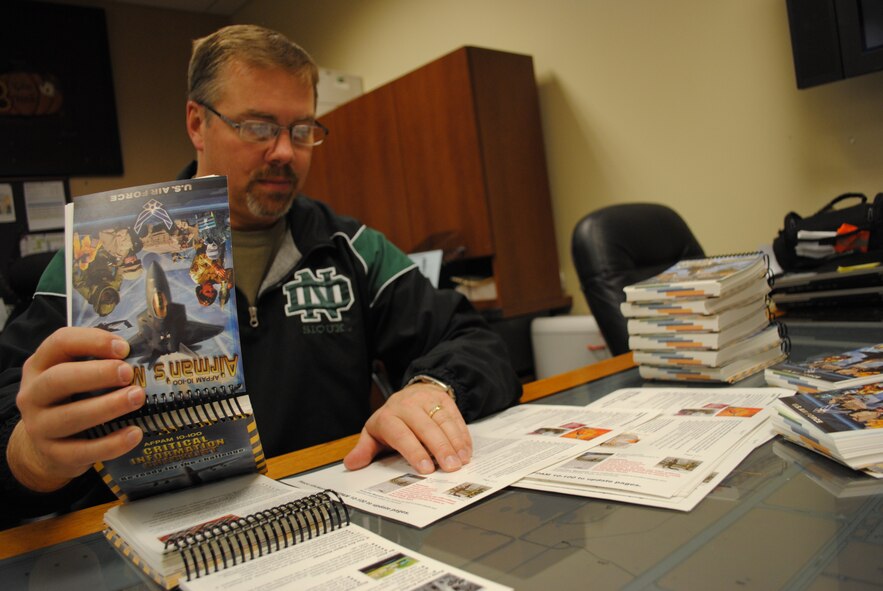 Scott Ross, 319th Operations Support Squadron unit deployment manager, verifies that a stack of Airman’s Manuals have been correctly updated prior to being issued to Airmen on March 15, 2013, at his office on Grand Forks Air Force Base, N.D. Before becoming a civil servant, Ross retired as master sergeant after 24 years of service in the Air Force. (U.S. Air Force photo/Senior Airman Luis Loza Gutierrez)
