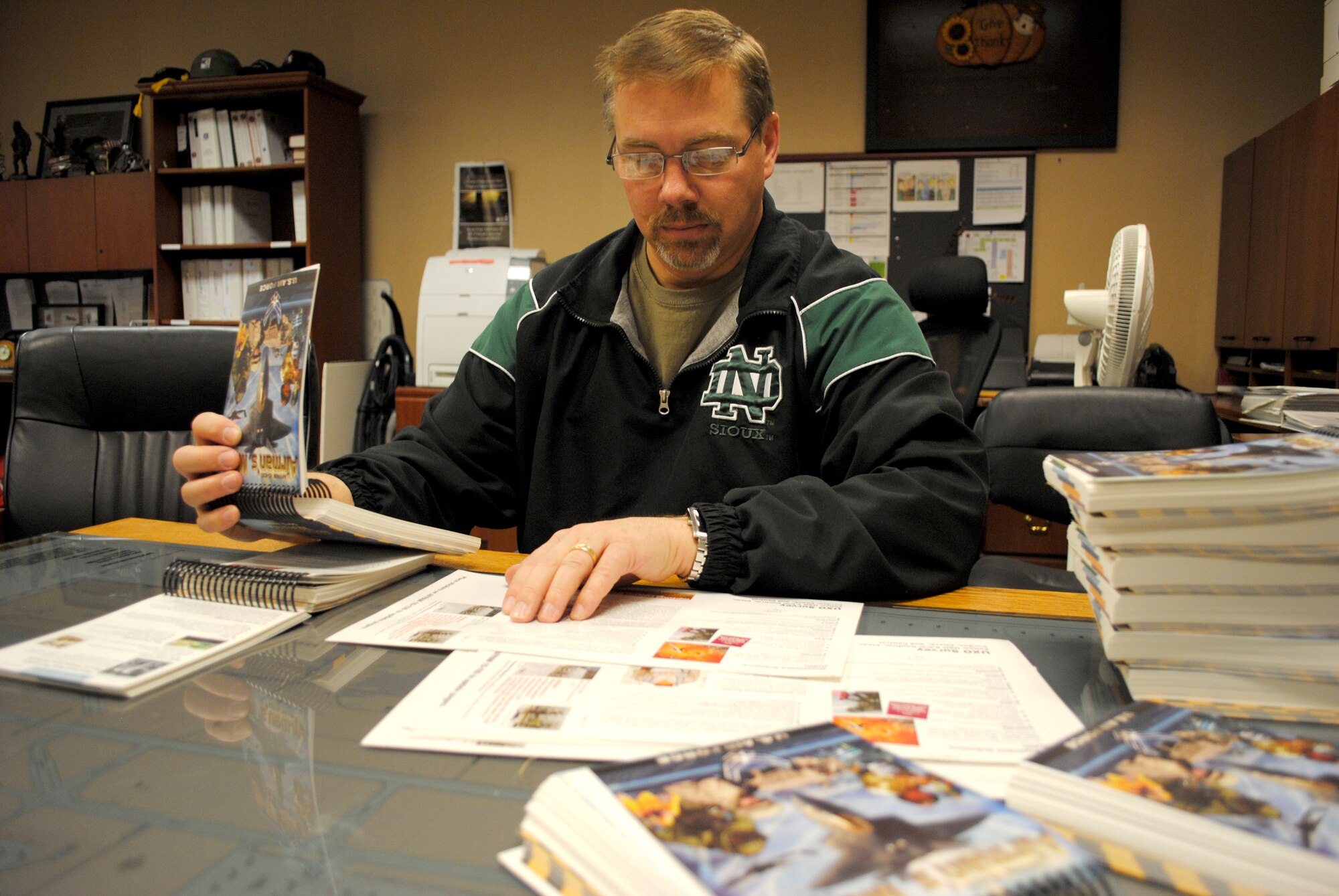 Scott Ross, 319th Operations Support Squadron unit deployment manager, verifies that a stack of Airman’s Manuals have been correctly updated prior to being issued to Airmen on March 15, 2013, at his office on Grand Forks Air Force Base, N.D. Before becoming a civil servant, Ross retired as master sergeant after 24 years of service in the Air Force. (U.S. Air Force photo/Senior Airman Luis Loza Gutierrez)
