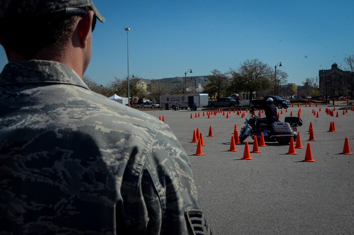 An Airman from Joint Base Charleston watches a deputy sheriff navigate through a motorcycle course during the Eighth Annual Palmetto Police Motorcycle Rodeo March 15, 2013 at the North Charleston Colisuem. More than 200 Airmen, Sailors, Soldiers, civilians and dependents participated in the 2013 Joint Base Charleston Motorcycle Safety Rodeo. More than 25 deputy sheriffs from South Carolina, Georgia and Florida completed obstacle courses designed to tests the limits of a motorcycle and the handling skills of the operators. (U.S. Air Force photo/Airman 1st Class Jared Trimarchi)