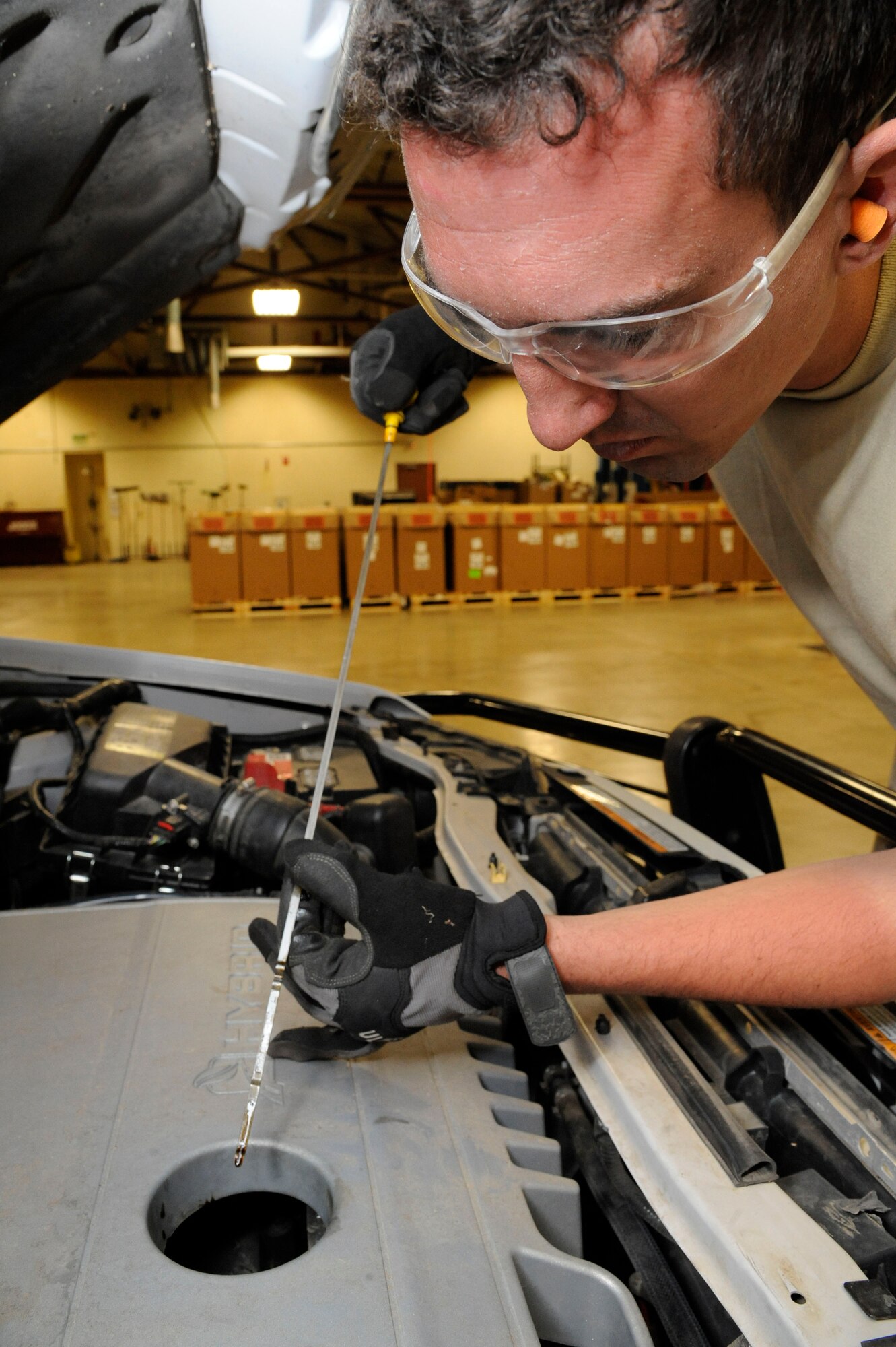 Staff Sgt. Davis McClain, 2nd Logistics Readiness Squadron Allied Trades section, checks the oil of a government owned vehicle on Barksdale Air Force Base, La., March 19. The allied trade shop's main responsibilities include tire repair and replacement and body work for Barksdale's fleet of vehicles ranging from fire trucks, maintenance and government owned vehicles. (U.S. Air Force photo/Airman 1st Class Andrew Moua)