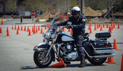 A deputy sheriff runs over a traffic cone during the Eighth Annual Palmetto  Police Motorcycle Rodeo March 15, 2013, at the North Charleston Coliseum. The event was part of the 2013 Joint Base Charleston Motorcycle Safety Rodeo. More than 200 Airmen, Sailors, Solders, civilians and dependents participated alongside more than 25 deputy sheriffs from South Carolina, Georgia and Florida. The Rodeo consisted of obstacle courses designed to tests the limits of a motorcycle and the handling skills of the operators. (U.S. Air Force photo/Airman 1st Class Jared Trimarchi)