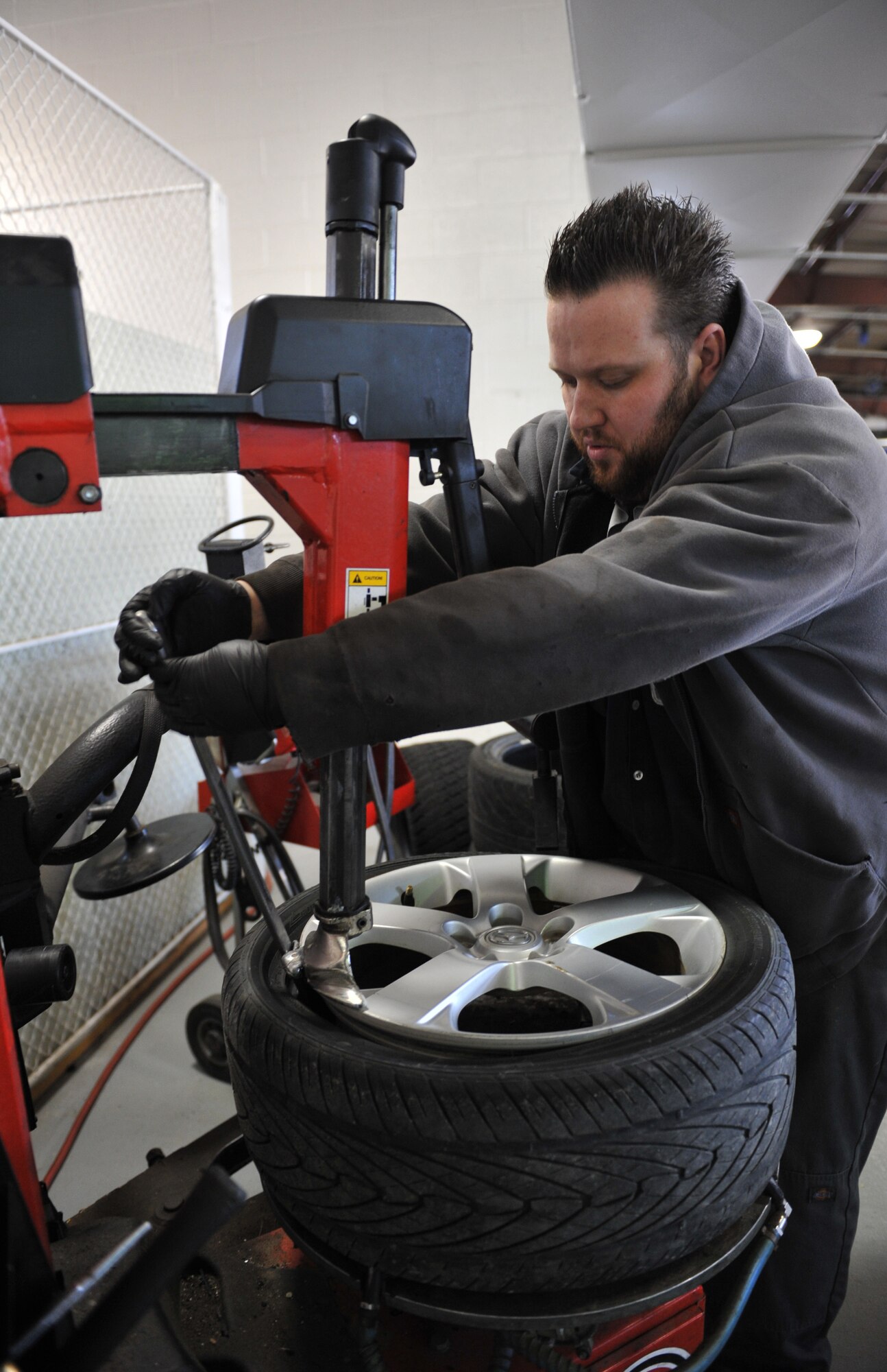 Jacob Gooden, 509th Force Support Squadron Spirit Auto automotive technician, changes out a tire at Whiteman Air Force Base, Mo., March 13, 2013. Spirit Auto is a one-stop shop that aims to provide honest, reliable and quality customer service. (U.S. Air Force photo by Heidi Hunt/Released)
