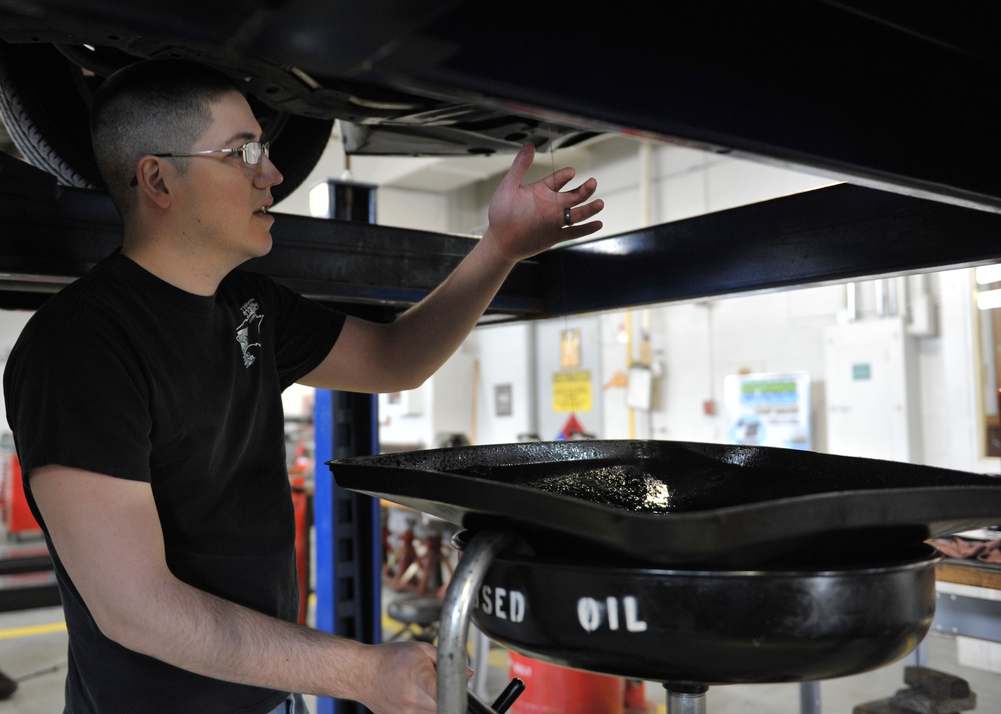 Senior Airman David Sanchez, 509th Maintenance Squadron aerospace ground technician, performs a routine oil change on his vehicle at Spirit Auto, Whiteman Air Force Base, Mo., March 12, 2013. Customers can use a vehicle bay to conduct self-help projects on their vehicles, or make an appointment to have their car serviced. (U.S. Air Force photo by Heidi Hunt/Released)