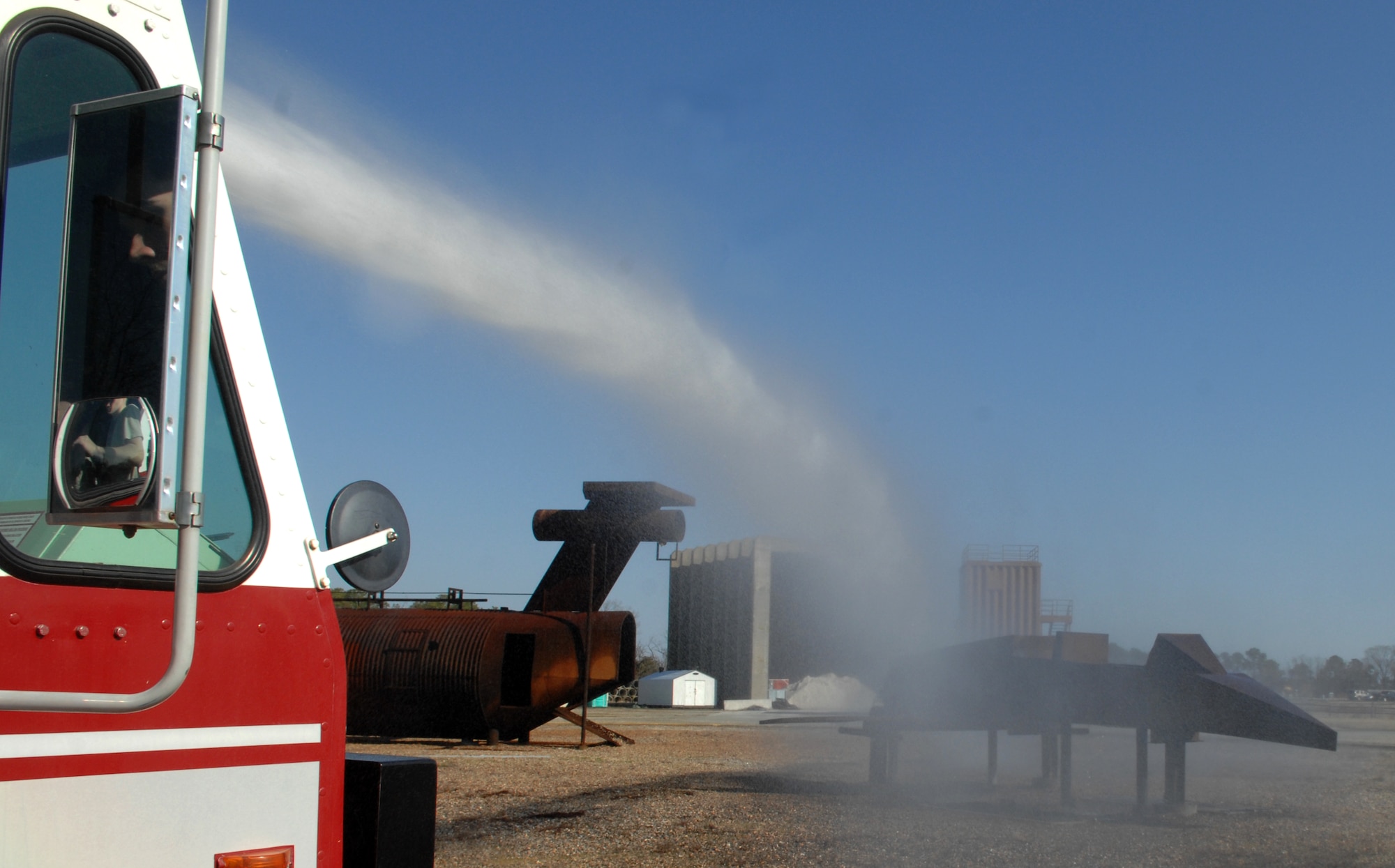 A crash truck cools down the burn pit after a live-fire exercise March 13, 2013, at Langley Air Force Base, Va. Firefighters use the burn pit to train with live fire conditions. (U.S. Air Force Photo by Airman 1st Class Austin Harvill/Released)