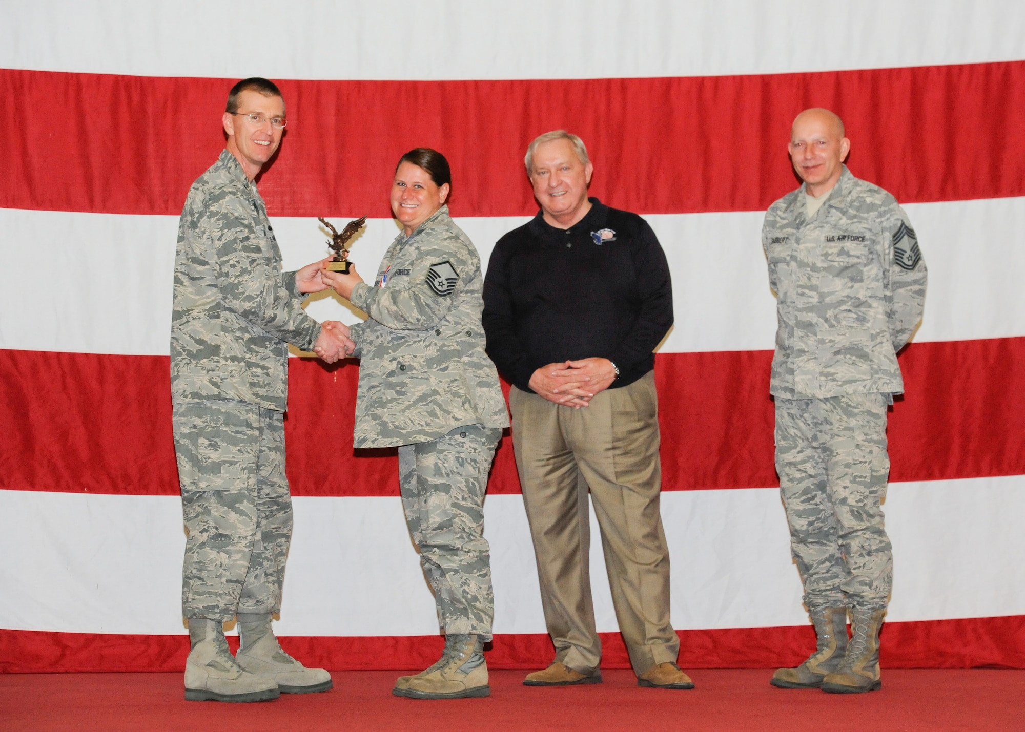 Master Sgt. Donna L. Moses, 325th Maintenance Group weapons standardization superintendent, receives the award for the Capt. Lance P. Sijan Award for Superior Leadership from Col. Curtis Hafer, 325th Maintenance Group commander, and Chief Master Sgt. Terry Gabbert, 325th MXG superintendent, and retired ninth Chief Master Sergeant of the Air Force, Chief Master Sgt. James Binnicker, during the 2012 Maintenance and Staff Professionals of the Year banquet in Hangar 1 March 15. The MPOY banquet recognizes the achievements of the maintenance group and honors maintenance professionals each year. (U.S. Air Force photo by Chris Cokeing)
