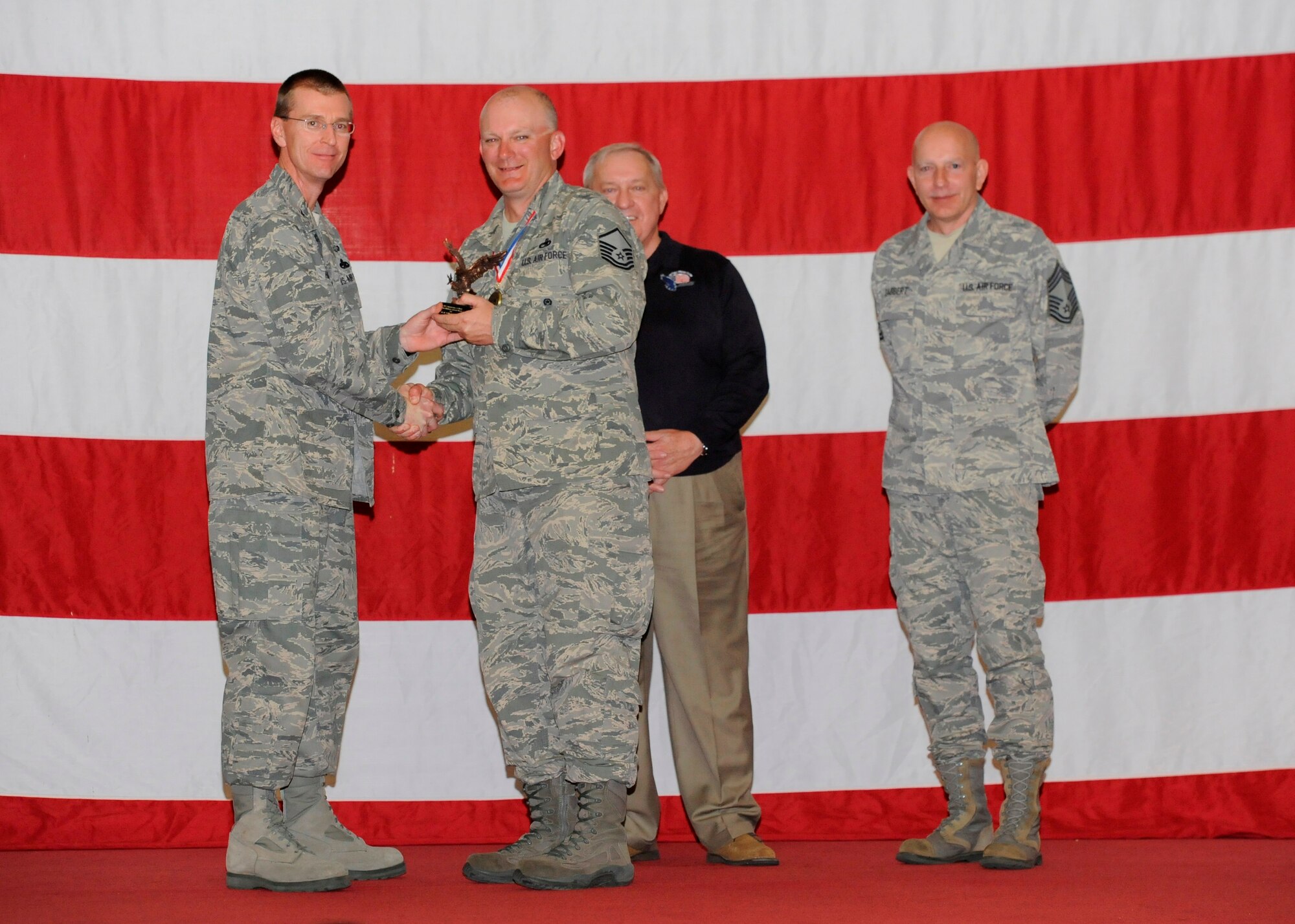 Master Sgt. John D. McAvoy, 325th Maintenance Squadron precision guided munitions NCO in charge, receives the awards for the Air Combat Command Outstanding Munitions Award and the Lt. Gen. Leo Marquez Award from Col. Curtis Hafer, 325th Maintenance Group commander, and Chief Master Sgt. Terry Gabbert, 325th MXG superintendent, and retired ninth Chief Master Sergeant of the Air Force, Chief Master Sgt. James Binnicker, during the 2012 Maintenance and Staff Professionals of the Year banquet in Hangar 1 March 15. The MPOY banquet recognizes the achievements of the maintenance group and honors maintenance professionals each year. (U.S. Air Force photo by Chris Cokeing)
