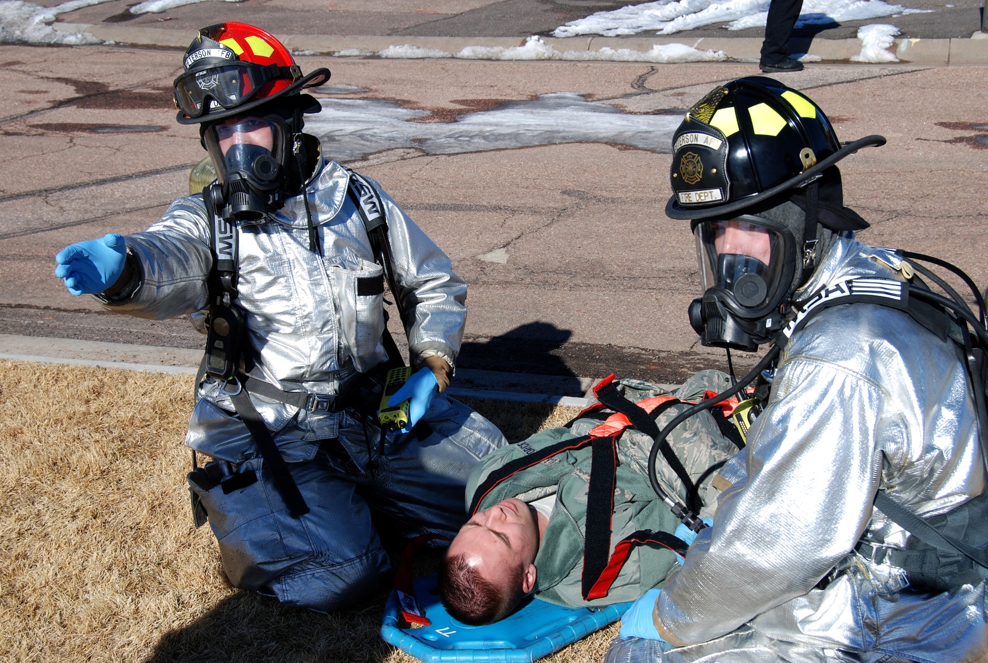 First responders from the 21st Civil Engineer Squadron fire department treat a casualty from a three vehicle accident on Hamilton Avenue during the Condor Crest exercise Feb. 28. The accident scenario was caused by an ice storm and resulted in a fuel spill, 20 casualties and two deaths. The Condor Crest emergency response exercise was held Feb. 25-March 1 as part of the 21st Space Wing's continued commitment to ensure base readiness. (U.S. Air Force photo/Lea Johnson)