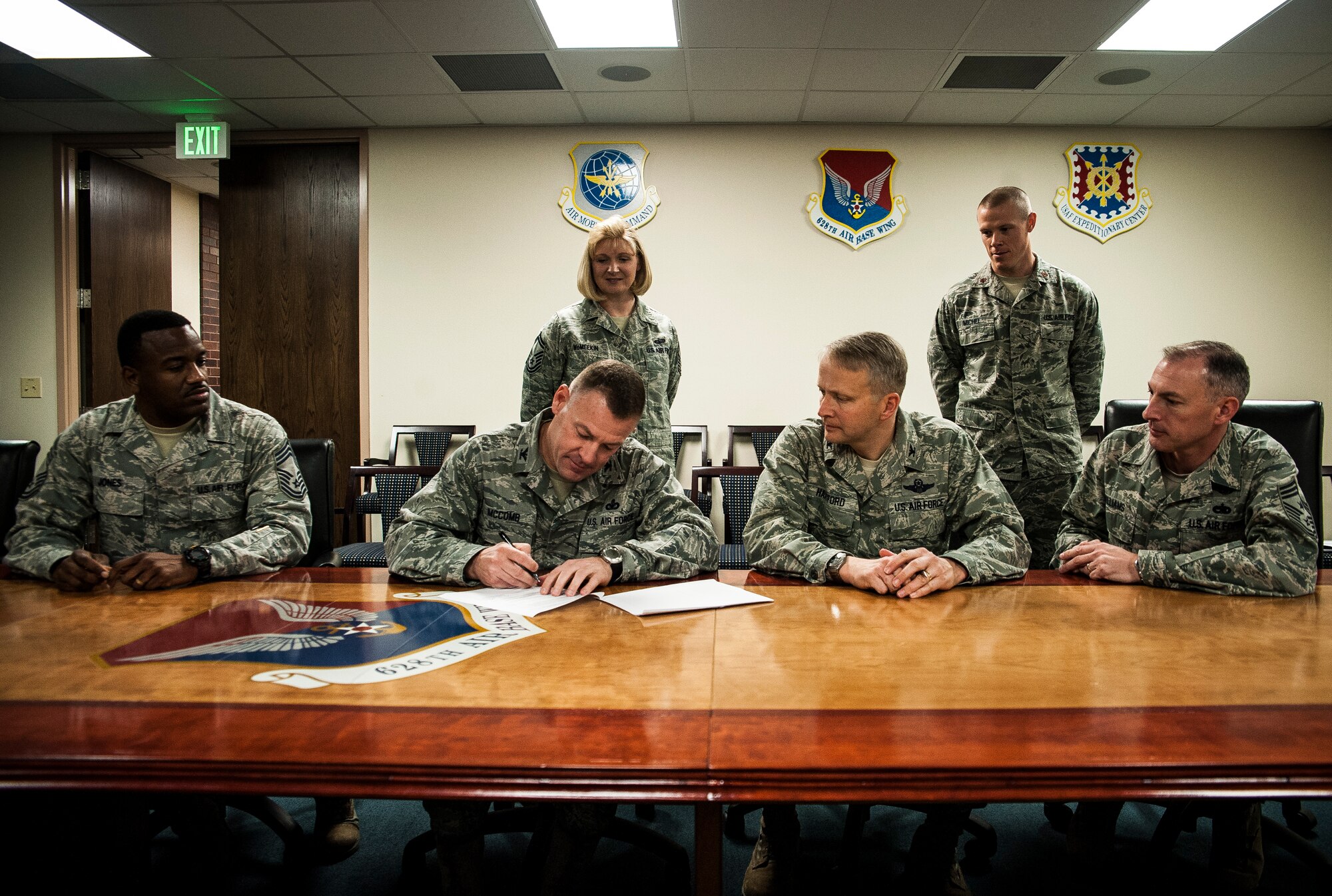 Colonel Richard McComb, Joint Base Charleston commander, and Col. Darren Hartford, 437th Airlift Wing commander, sign the DUI Battle Plan March 13, 2013, while Chief Master Sgt. Avery Jones, 628th Mission Support Group superintendent, Senior Master Sgt. Michelle McMeekin, 628th Force Support Squadron career assistant advisor, Maj. Michel Daniel, 628th Medical Group director of psychological health, and Chief Master Sgt. Larry Williams, 437th Airlift Wing command chief, attend the signing. The DUI Battle Plan is a comprehensive campaign aimed at reducing drunk driving and reinforcing positive life choices.  The battle plan was modeled after a campaign launched at Travis Air Force Base, Calif.  The plan reduced DUIs by 42 percent after only one year of implementation at Travis. Locally, the campaign will be officially kicked off on April 1. (U.S. Air Force photo/ Senior Airman Dennis Sloan)